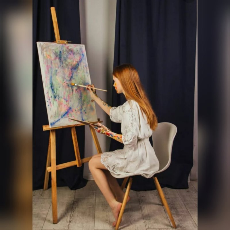 Рисует на мольберте